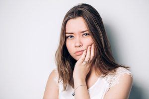 patient holding cheek in pain