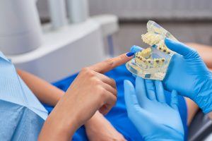 dentist showing patient model of teeth with metal braces